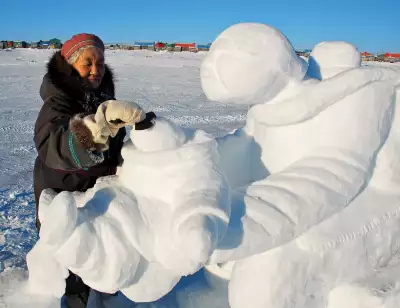 Nunavik | A woman creates a snow sculpture at Puvirnituq Snow Festival
