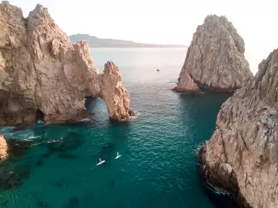 Los Cabos | Two paddle boarders paddle their way through the Arch of Cabo San Lucas