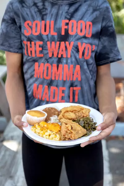 Myrtle Beach | A hand holds a plate of chicken, mac and cheese, collard greens and cornbread at Big Mike's Soul Food in Myrtle Beach