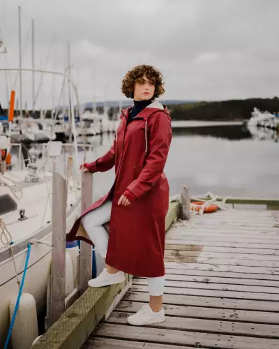 Someone wearing The Mernini raincoat in red