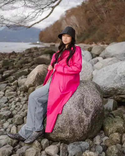 Someone wearing The Mernini raincoat in fuschia and the Rain Hat