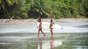 Tourism industry recovery | Two women surf with Origin Travels