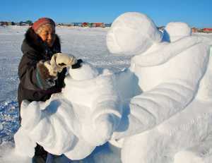 Nunavik | A woman creates a snow sculpture at Puvirnituq Snow Festival