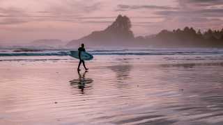 What to do in Tofino | A surfer on the beach of Cox Bay during sunset