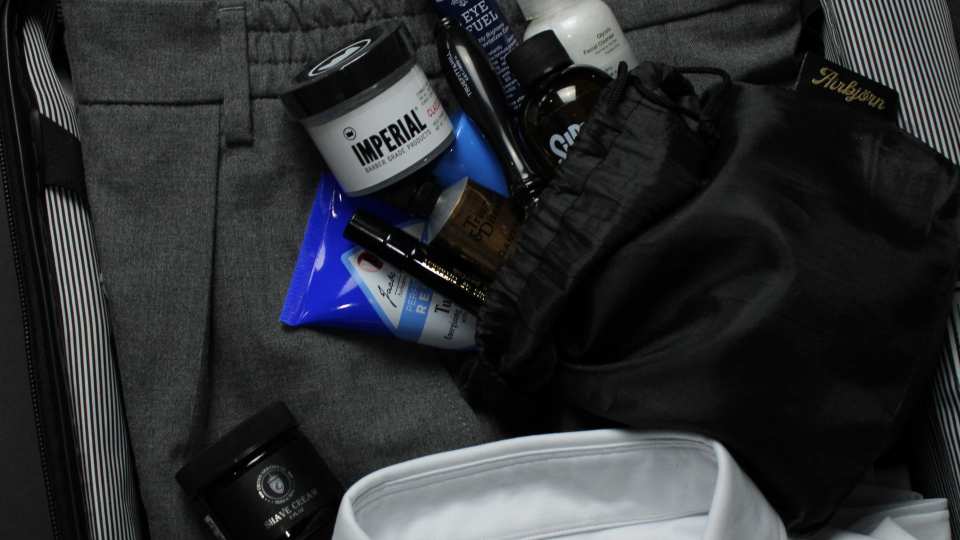 AirBjörn travel toiletry kit being packed with men's clothing