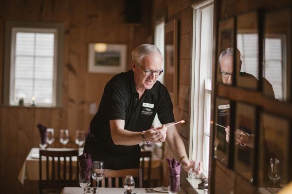 Trinity, Newfoundland | A man lighting candles at Twine Loft