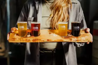 Trinity, Newfoundland | Someone carrying a flight of beer at Port Rexton Brewing