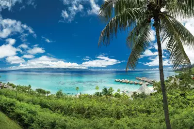 A panoramic view of the beach and overwater bungalows in Mo'orea, French Polynesia