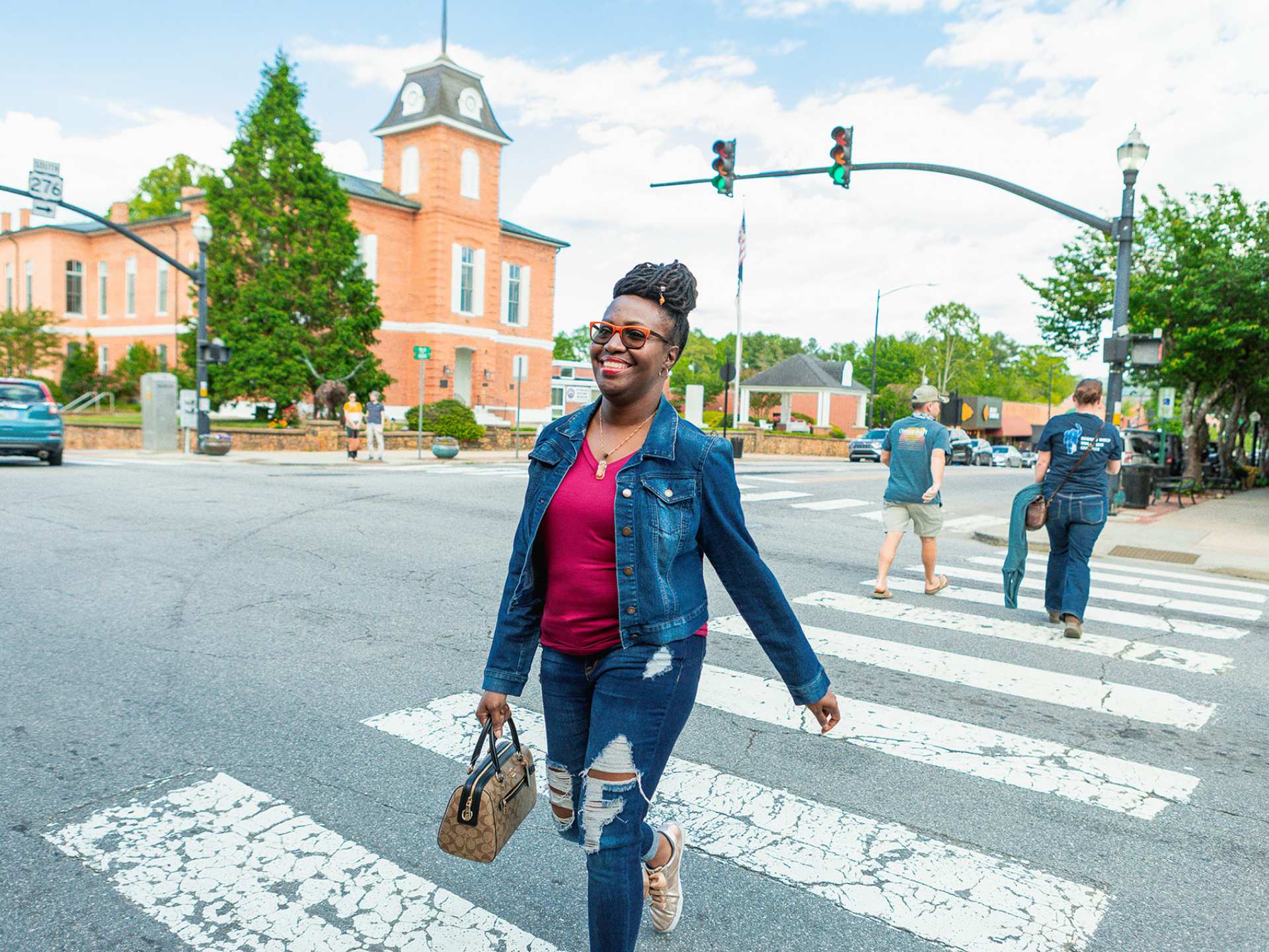 North Carolina | A woman walking across the street and smiling in Brevard, North Carolina