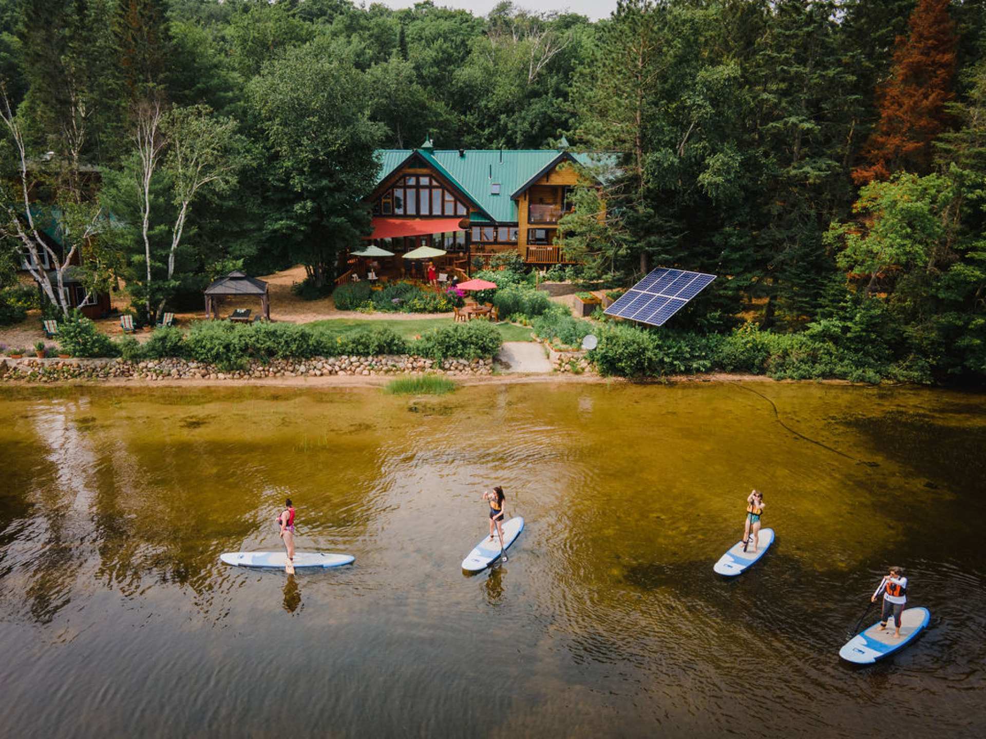 Ontario wellness retreats | Paddle boarders on the lake at Northern Edge Algonquin Ontario wellness retreat