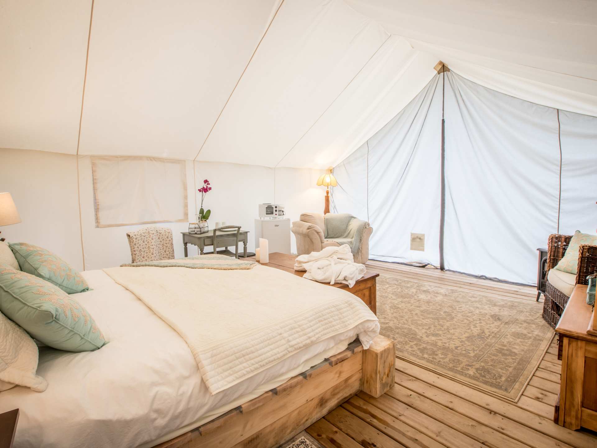 Ontario wellness retreats | A bed, pillows and tables in a tent at Whispering Springs Ontario wellness retreat