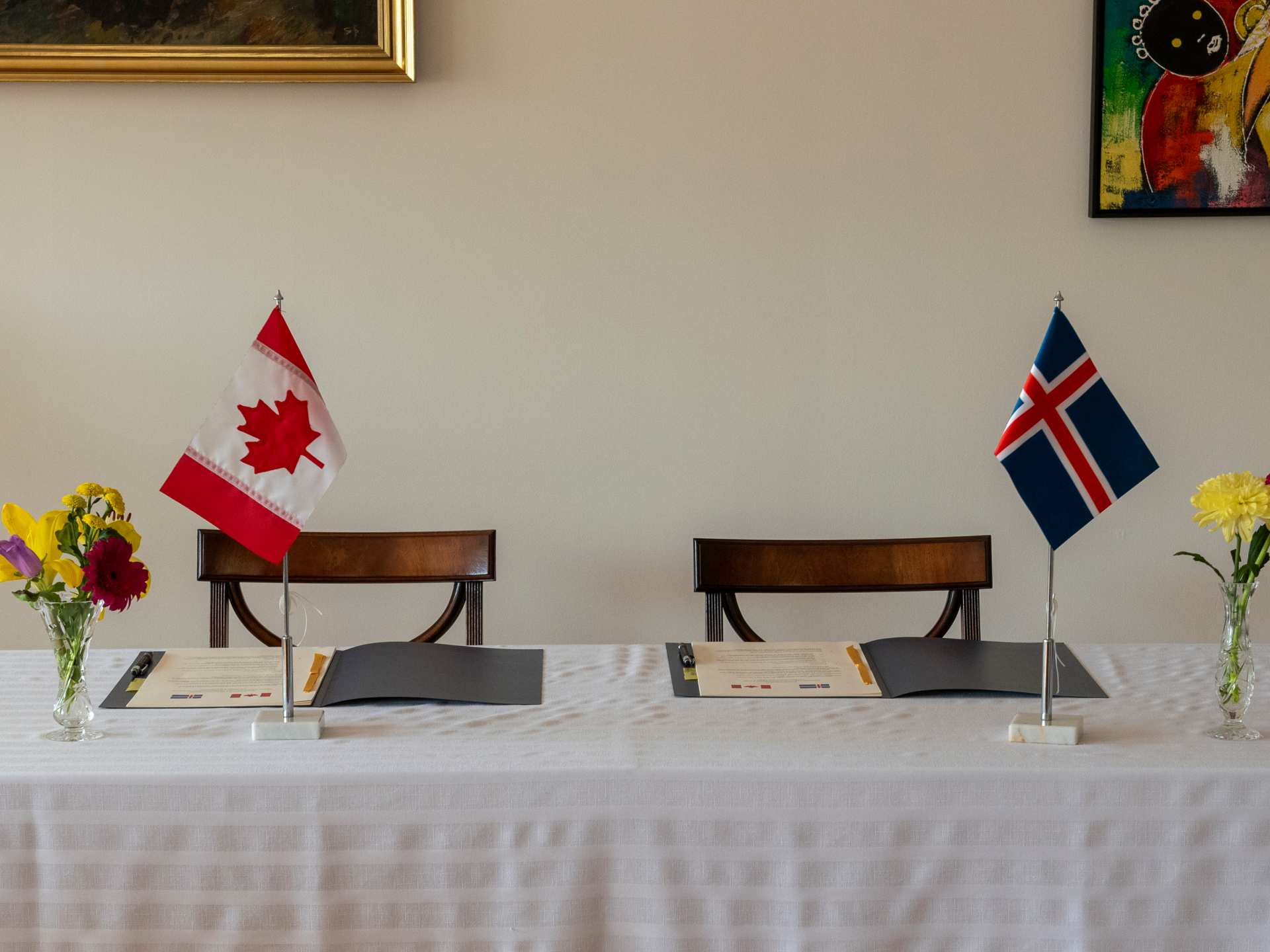 A white tablecloth table with a Canadian and Icelandic flag