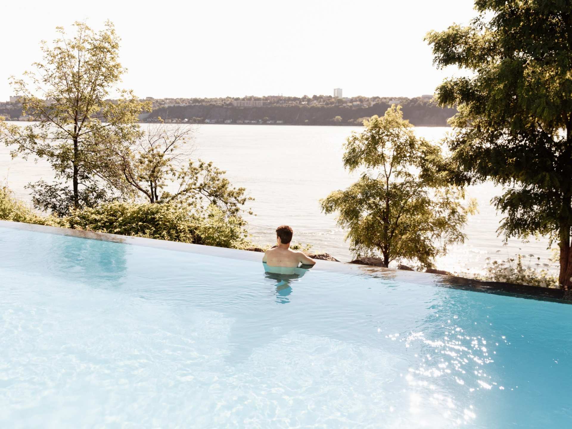Québec Nordic spa | A person sitting in the infinity pool at Strøm Nordic Spa — Old Québec