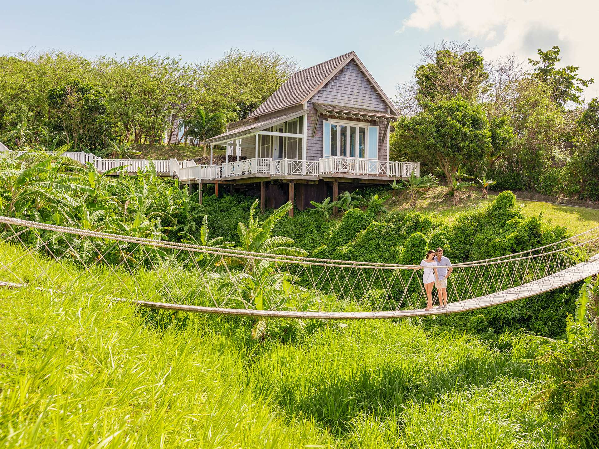 A couple crossing a rope bridge in St. Kitts