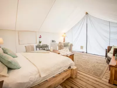 Ontario wellness retreats | A bed, pillows and tables in a tent at Whispering Springs Ontario wellness retreat