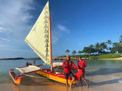 Captain Zach Arreola-Chun and his crew member Kai in front of their Hawaiian canoe