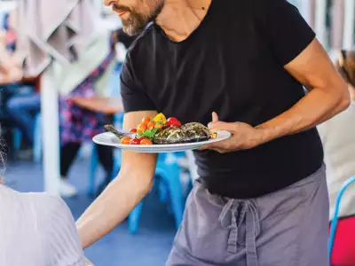 Mississauga | Server holding a plate with fish topped with vegetables