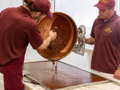 Mackinac Island | Two employees pouring fudge on a pan at Joann's Fudge on Mackinac Island