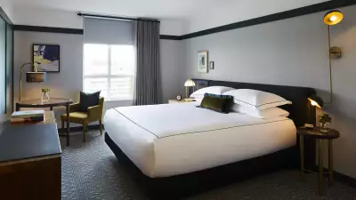 A deluxe king bed at the Kimpton Saint George Hotel