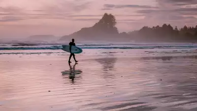 What to do in Tofino | A surfer on the beach of Cox Bay during sunset