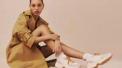 Veja X Reformation Sneakers | A woman wearing a trench coat and sneakers