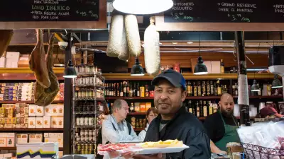 Kimpton Saint George | A man serving a tray full of food at a local restaurant