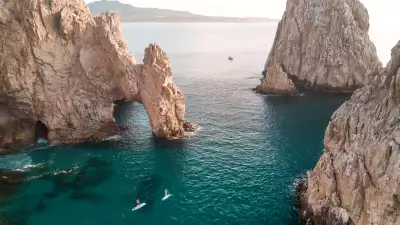 Los Cabos | Two paddle boarders paddle their way through the Arch of Cabo San Lucas