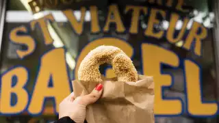 Montreal bagels | A bagel held up outside of St-Viateur Bagel