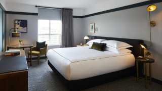 A deluxe king bed at the Kimpton Saint George Hotel