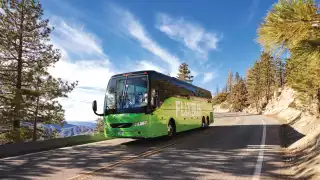 A Flixbus winding its way through a mountainous landscape