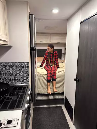 Taylor Newlands sitting on the bed in a CanaDream RV