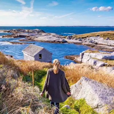 Woman looking out at rocks and water in Nova Scotia