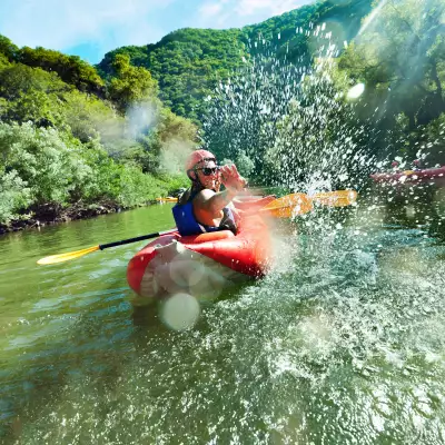 Man flicking water at the camera in a kayak