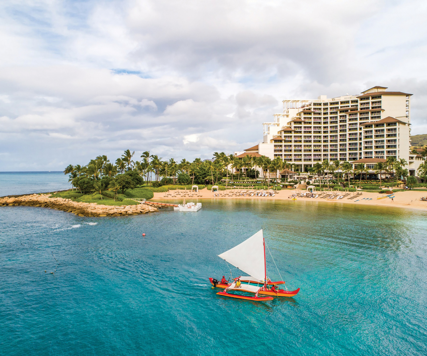 A Hawaiian canoe sails off the shore of the Four Seasons Resort Oahu