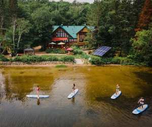 Ontario wellness retreats | Paddle boarders on the lake behind Northern Edge Algonquin wellness retreat