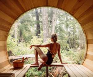 Hotel Zed Tofino | A woman lounges inside the barrel sauna and admires the rainforest view