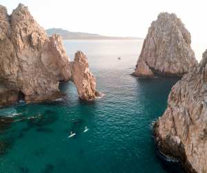 Los Cabos | Two paddle boarders paddle their way through the Arch of Cabo San Lucas