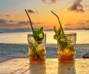 The best Caribbean islands to visit | The sun sets behind two tropical cocktails