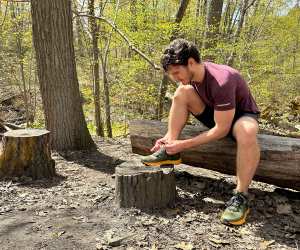 Columbia hiking shoes | Hunter Gutman sits on a log in the forest tying his hiking shoes