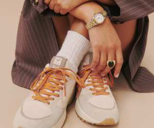 Veja X Reformation Sneakers | A woman is seated wearing a watch and sneakers