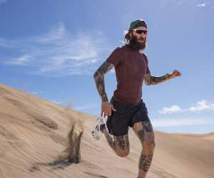 A man running in the desert wearing the Men Merino Blend 75 Cool LiteTM Featherlight SS Crewe