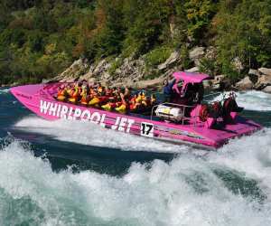 A boat with people wearing life jackets on the Niagara river rapids