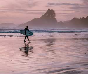 What to do in Tofino | A surfer on the beach of Cox Bay during sunset