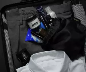 AirBjörn travel toiletry kit being packed with men's clothing
